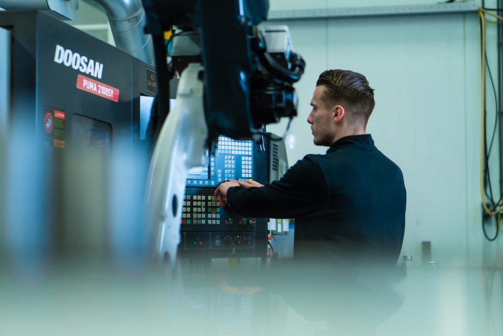 Machine operator van BMO automation werkt aan de verspaning software van een Doosan machine.